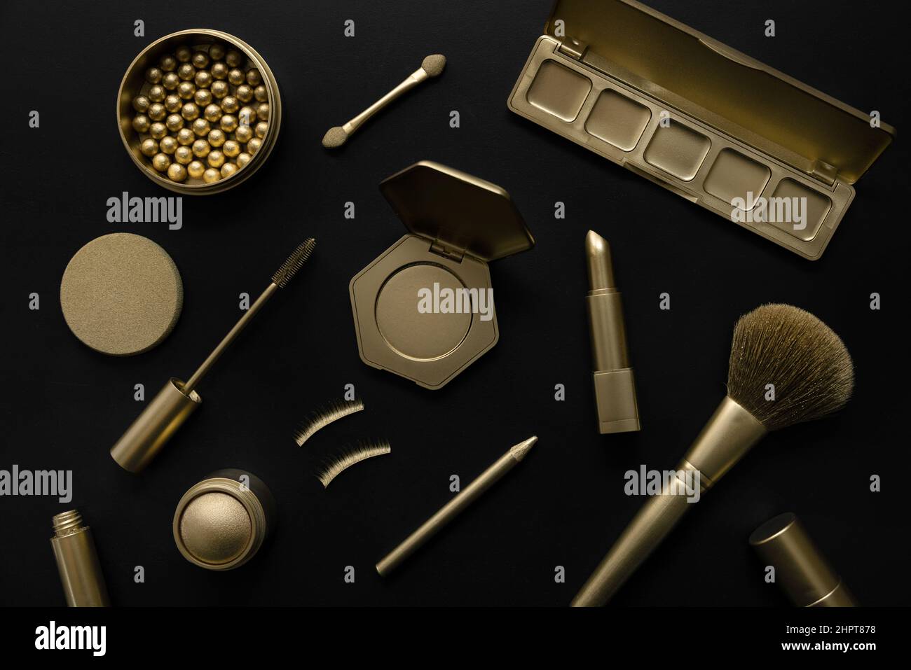 Luxus-Kosmetik - Set mit goldenen dekorativen Make-up-Produkten auf schwarzem Hintergrund. Draufsicht Stockfoto