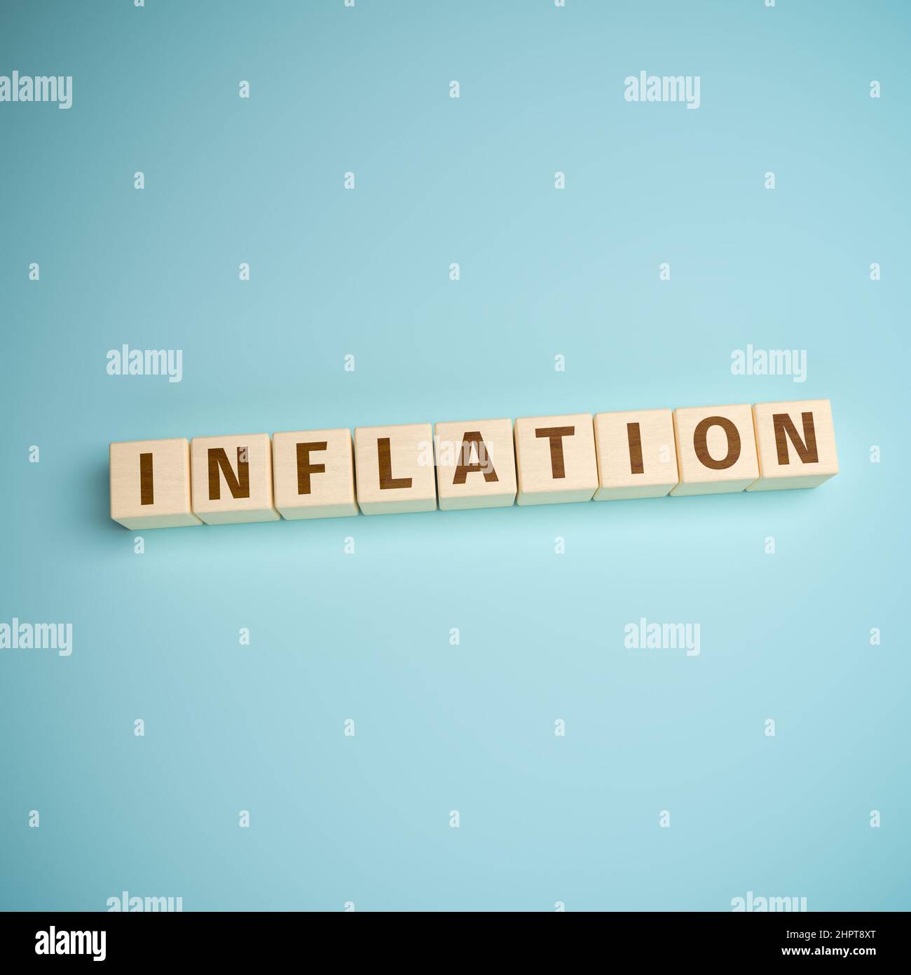 Das Wort Inflation wurde aus Spielzeugblöcken auf türkisfarbenem Hintergrund gebaut Stockfoto
