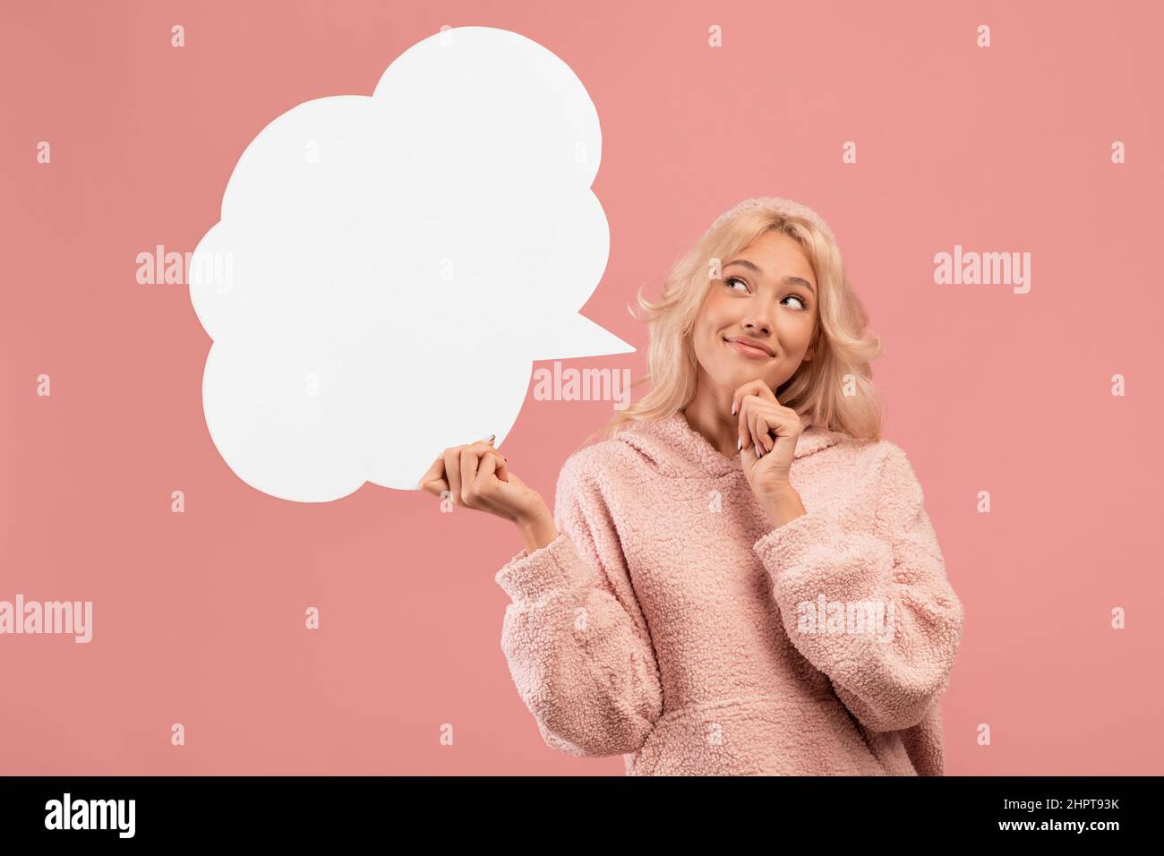 Ideenkonzept. Nachdenkliche Frau hält und schaut auf leere Sprechblase mit freiem Platz für Ihr Design Stockfoto