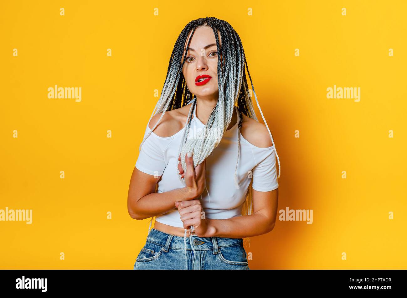 Porträt einer wütenden Frau mit Dreadlocks. Hände halten Dreadlocks. Stockfoto