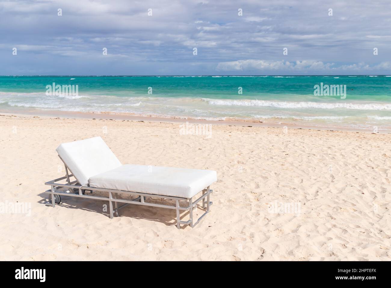 Weiße Sonnenliege steht an einem sonnigen Tag an einem Sandstrand, Dominikanische Republik, Bavaro Beach Stockfoto