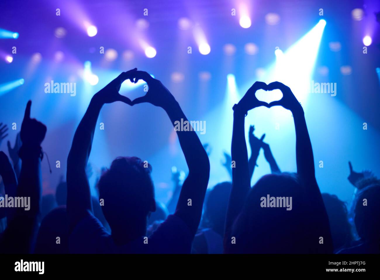 Ihre Liebe zu zeigen. Aufnahme von anbetenden Fans bei einem Rockkonzert. Stockfoto