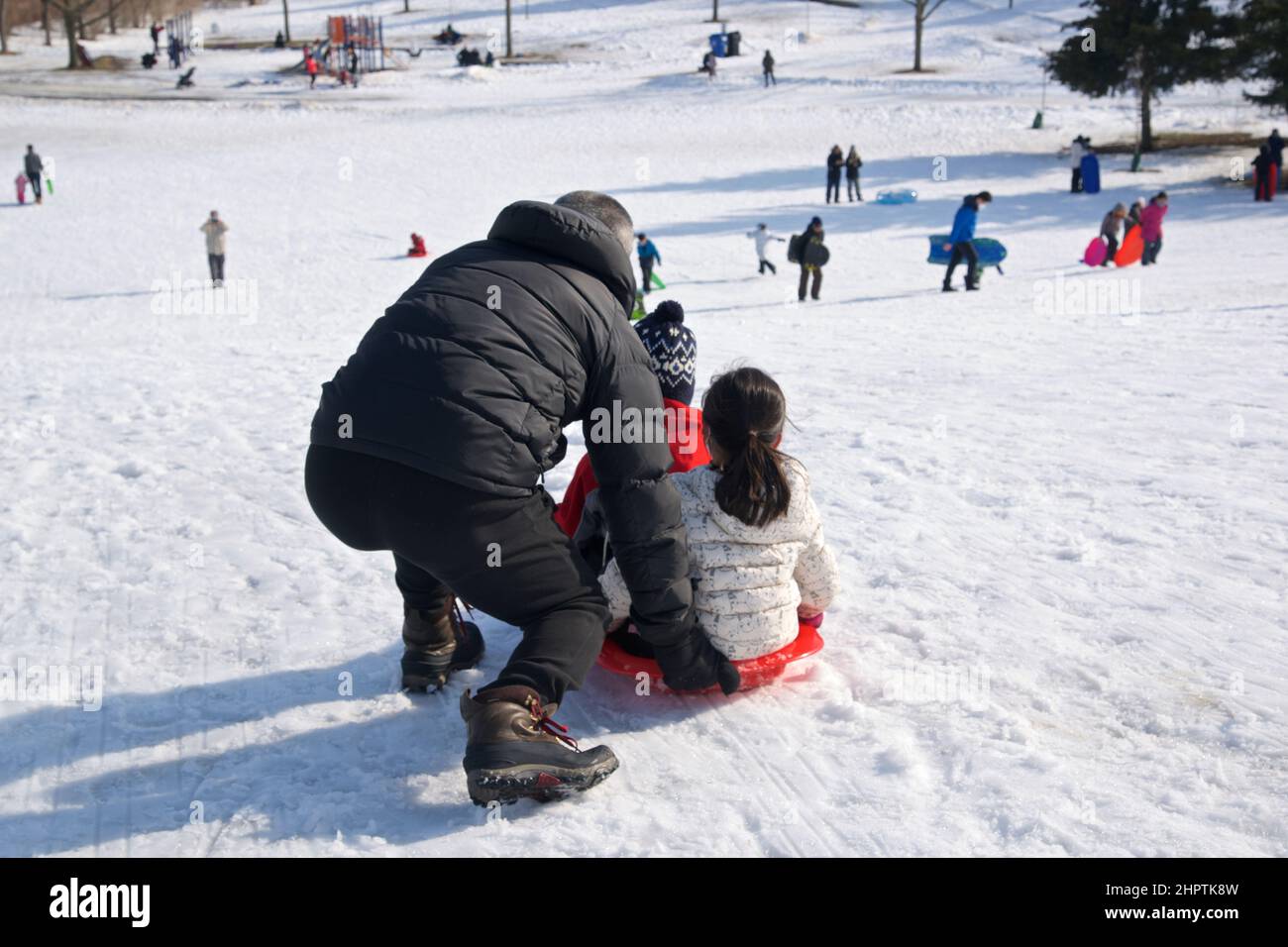 Wintersport-Rodel - Vater und Tochter spielen Rodel, Winter, draußen, gesunde Lebensweise. Stockfoto