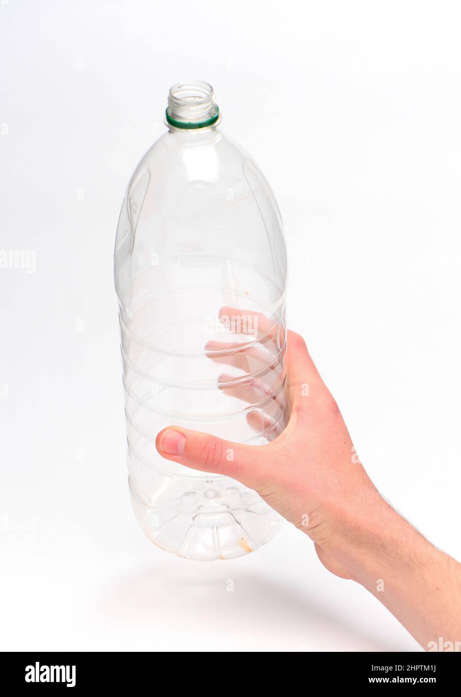 Hand hält eine Einweg-Kunststoff-Getränkeflasche bereit für das Recycling vor einem weißen Hintergrund fotografiert. Stockfoto