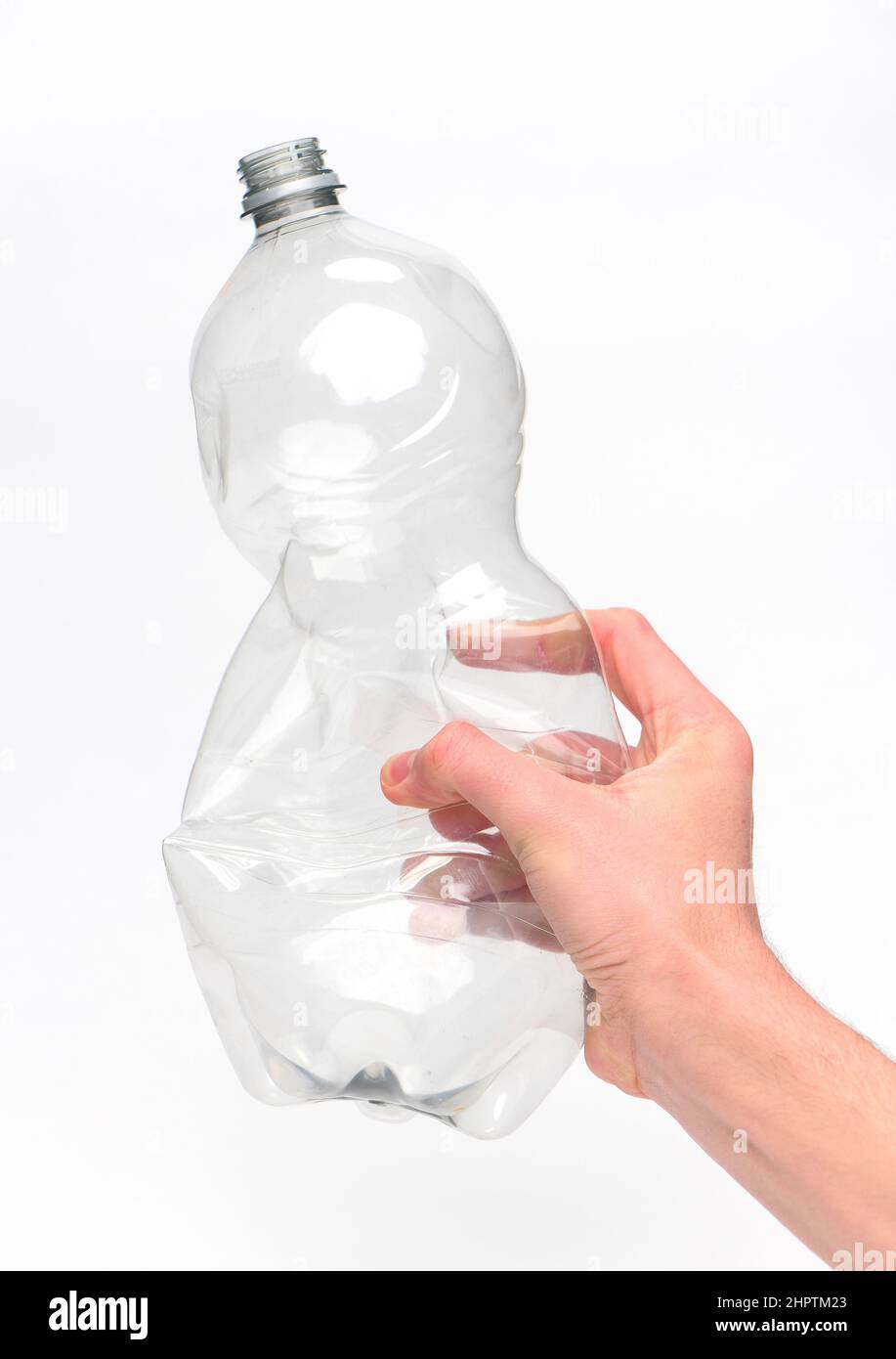 Hand hält eine Einweg-Kunststoff-Getränkeflasche bereit für das Recycling vor einem weißen Hintergrund fotografiert. Stockfoto