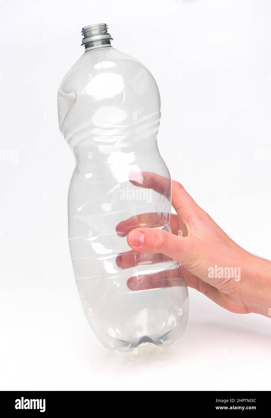 Hand hält eine Einweg-Kunststoff-Getränkeflasche bereit für das Recycling vor einem weißen Hintergrund fotografiert. Stockfoto