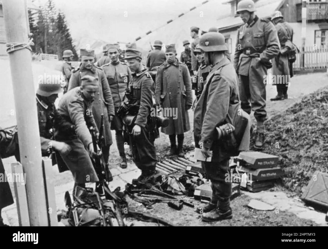 JUGOSLAWISCHE SOLDATEN geben ihre Waffen etwa 1941 an deutsche Soldaten ab. Stockfoto