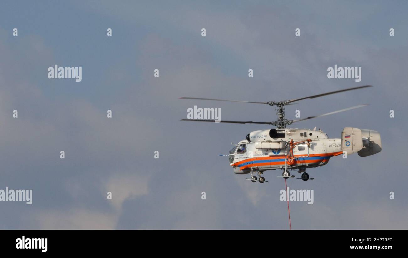 Moskau Russland AUGUST, 26, 2015 Hubschrauber mit koaxialen Rotoren mit Wasserkorb, der vom baryzentrischen Haken hängt, um Feuer zu löschen. Hubschrauber Kamov Ka-32 des russischen Katastrophenministeriums Stockfoto
