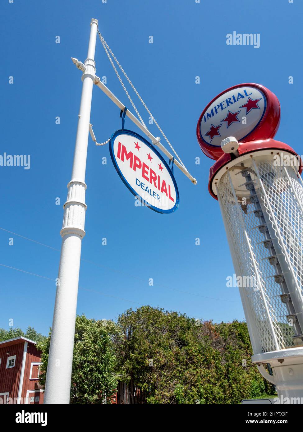 Vintage Imperial Gas Pump: Ein imperiales Schild mit einer alten Gaspumpe hinter einem strahlend blauen Himmel. Stockfoto
