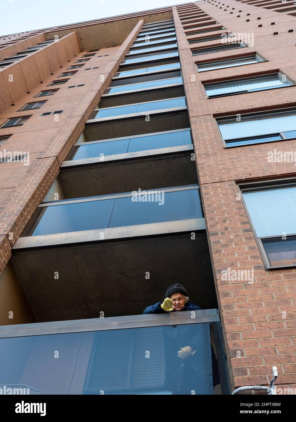Wellenbesuch in einem Altersheim in Pandemic Lockdown: Während der globalen COVID-19-Pandemie 2020-2021 winkt eine ältere Frau von ihrem Balkon in einem Altersheim in Ottawa. Stockfoto