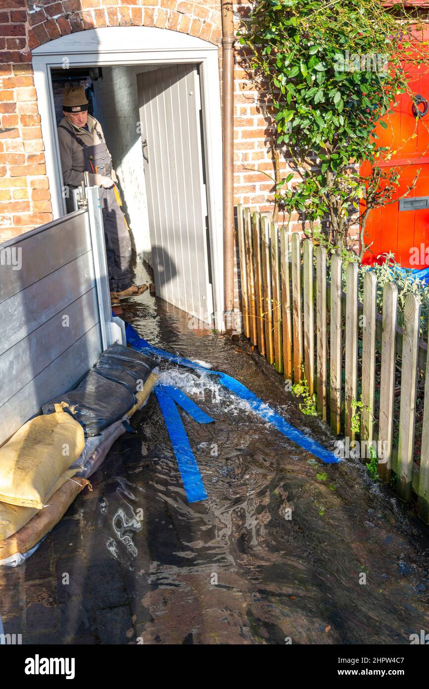 Bewdley, Worcestershire, England, UK- Februar 22 2022: Ein Bewohner versucht, Wasser aus einem Häuschen am Rande des Flusses Severn zu evakuieren, und mehr Flo Stockfoto