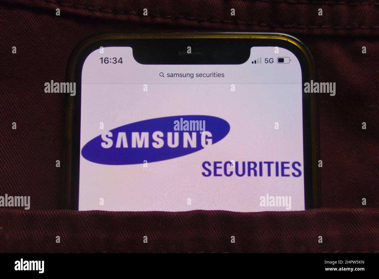 KONSKIE, POLEN - 22. Februar 2022: Das Unternehmenslogo von Samsung Securities wird auf dem Mobiltelefon in der Jeanentasche versteckt angezeigt Stockfoto