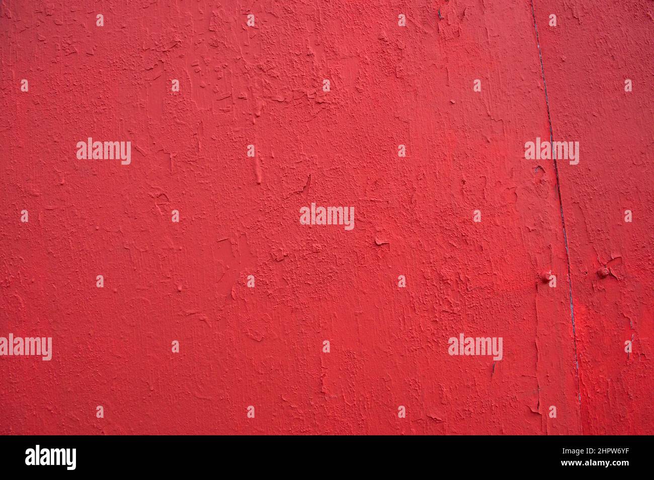 Struktur von rauen Betonwand bedeckt und rot dekorativen Stuck lackiert. Hintergrund aus blutrotem Gips mit Rissen an der Betonwand. Stockfoto