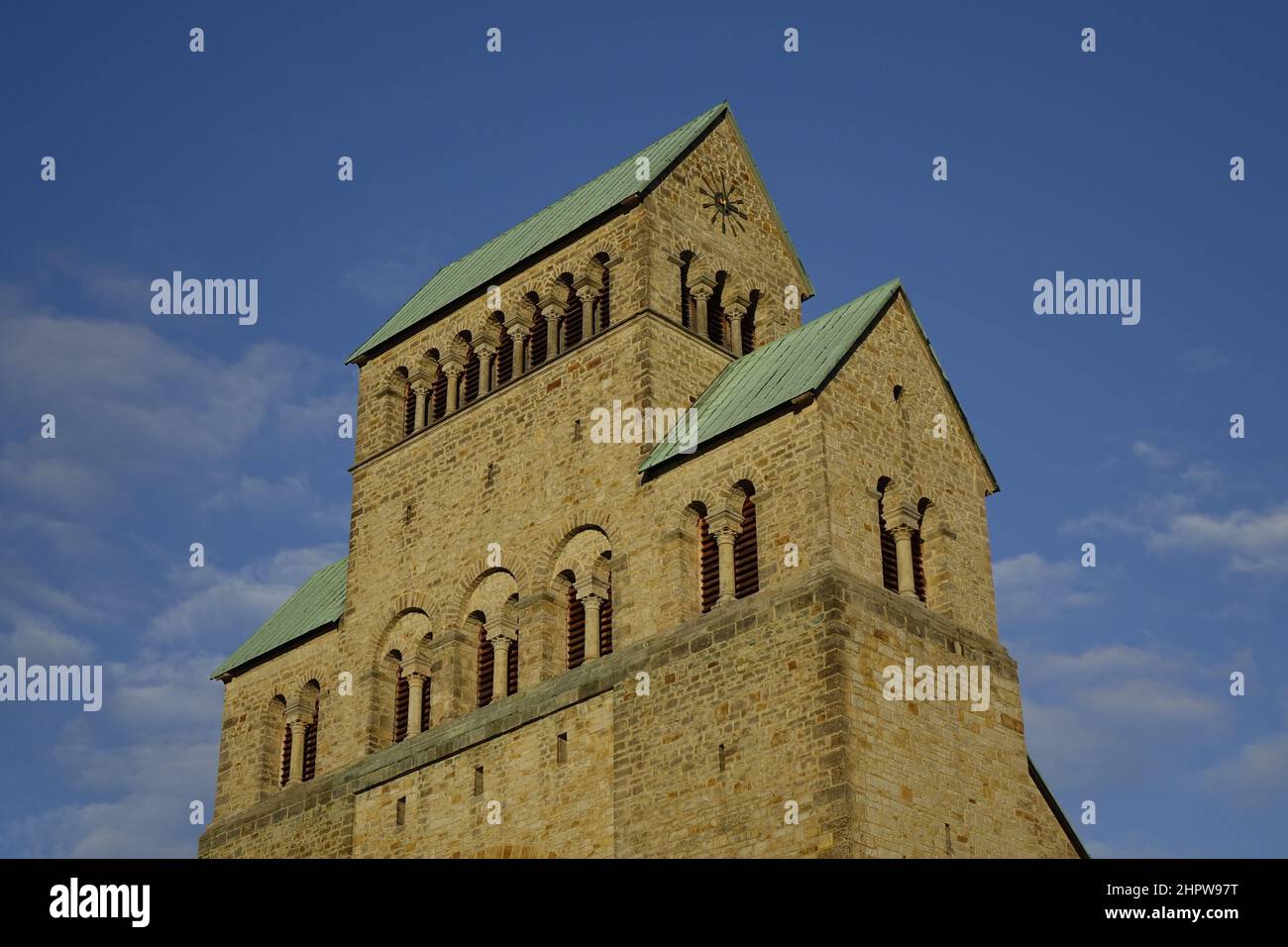 Hildesheimer Dom, gelber Sandstein-Uhrenturm mit grünen Dächern unter blauem Himmel an einem sonnigen Herbsttag, Hildesheim, Niedersachsen, Deutschland Stockfoto