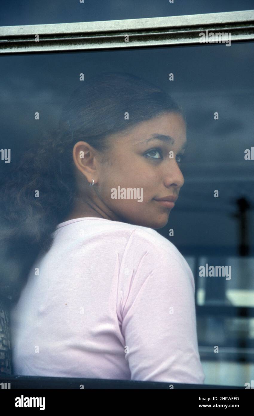 Unglückliches multikulturelles Teenager-Mädchen, das durch das Fenster des Busses schaut Stockfoto