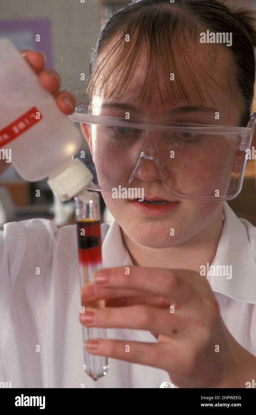 Schüler der Oberstufe in Schutzbrillen, die im Klassenzimmer wissenschaftlichen Experimenten unterzogen werden Stockfoto