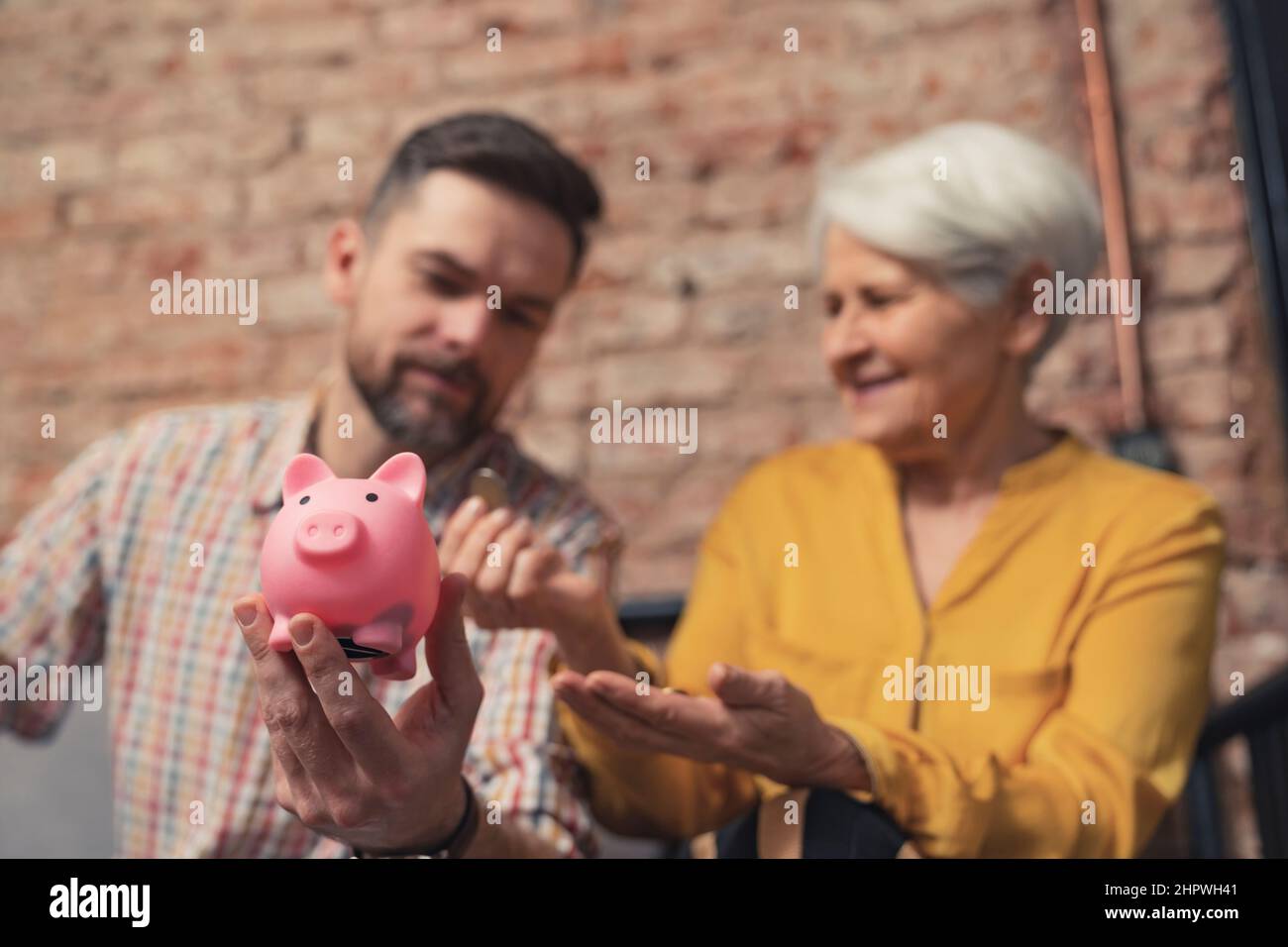 Der kaukasische Geschäftsmann überraschte die Art und Weise, wie seine ältere Mutter ihr Geld spart. Hochwertige Fotos Stockfoto
