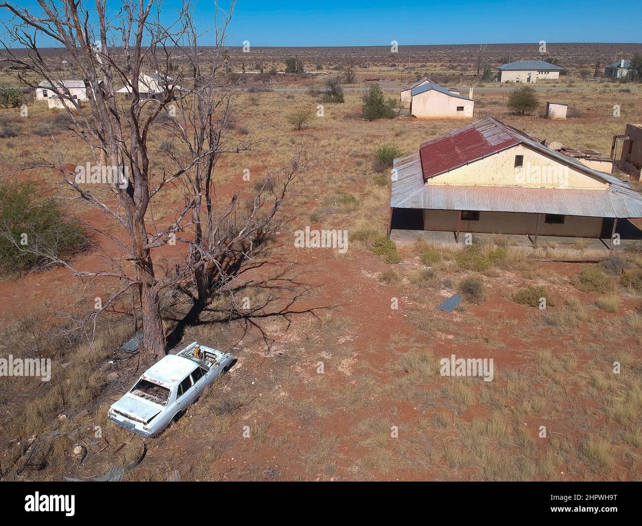 Luftaufnahme der Gebäude der Polizeiwache und eines Autowracks der verlassenen Eisenbahnstadt Putsonderwater, Geisterstadt in Südafrika. Stockfoto