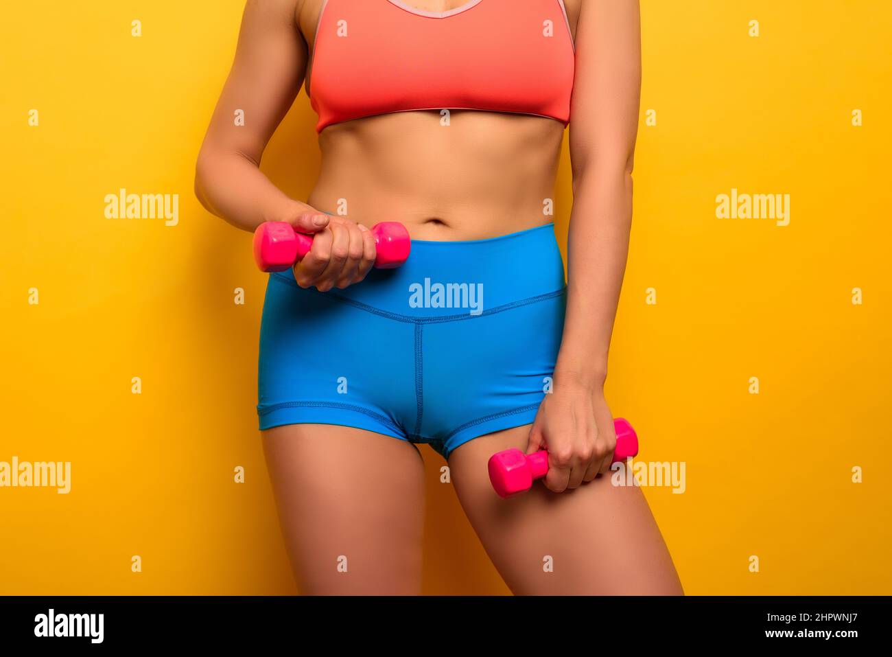Fit Frau trainiert mit Lenker auf gelbem Hintergrund Stockfoto