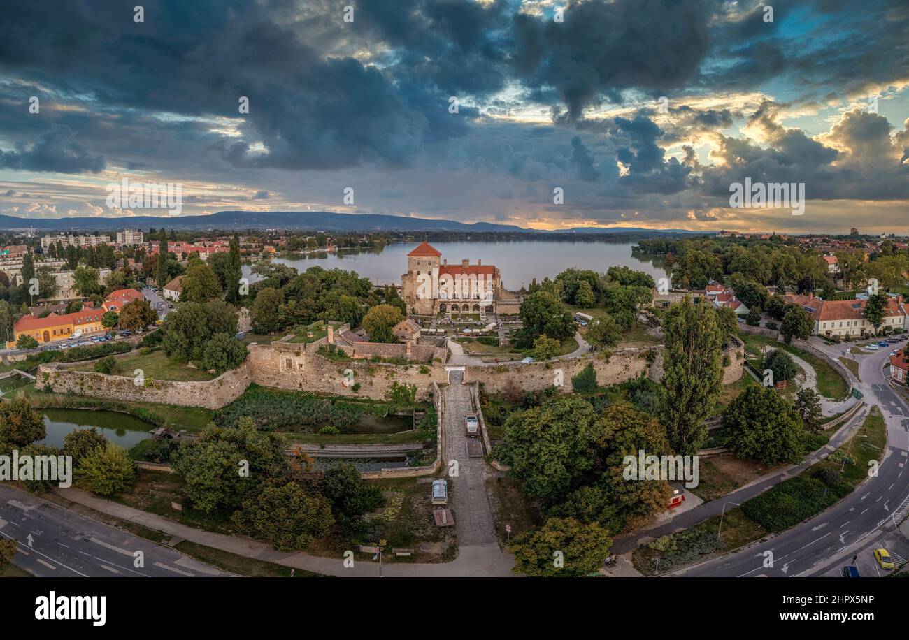 Luftaufnahme bei Sonnenuntergang über dem alten Tata-See mit mittelalterlicher Burg, umgeben von Graben, Bastionen und Mauern in Ungarn Stockfoto