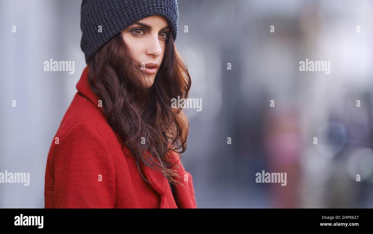 Tragen Sie im Zweifelsfall rot. Aufnahme einer schönen jungen Frau in Winterkleidung, die in einer städtischen Umgebung steht. Stockfoto