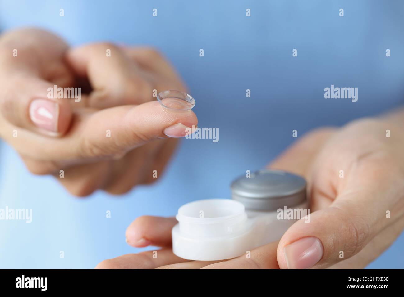 Kontaktlinsen für das Sehen und ein Behälter in den weiblichen Händen, verschwommen Stockfoto