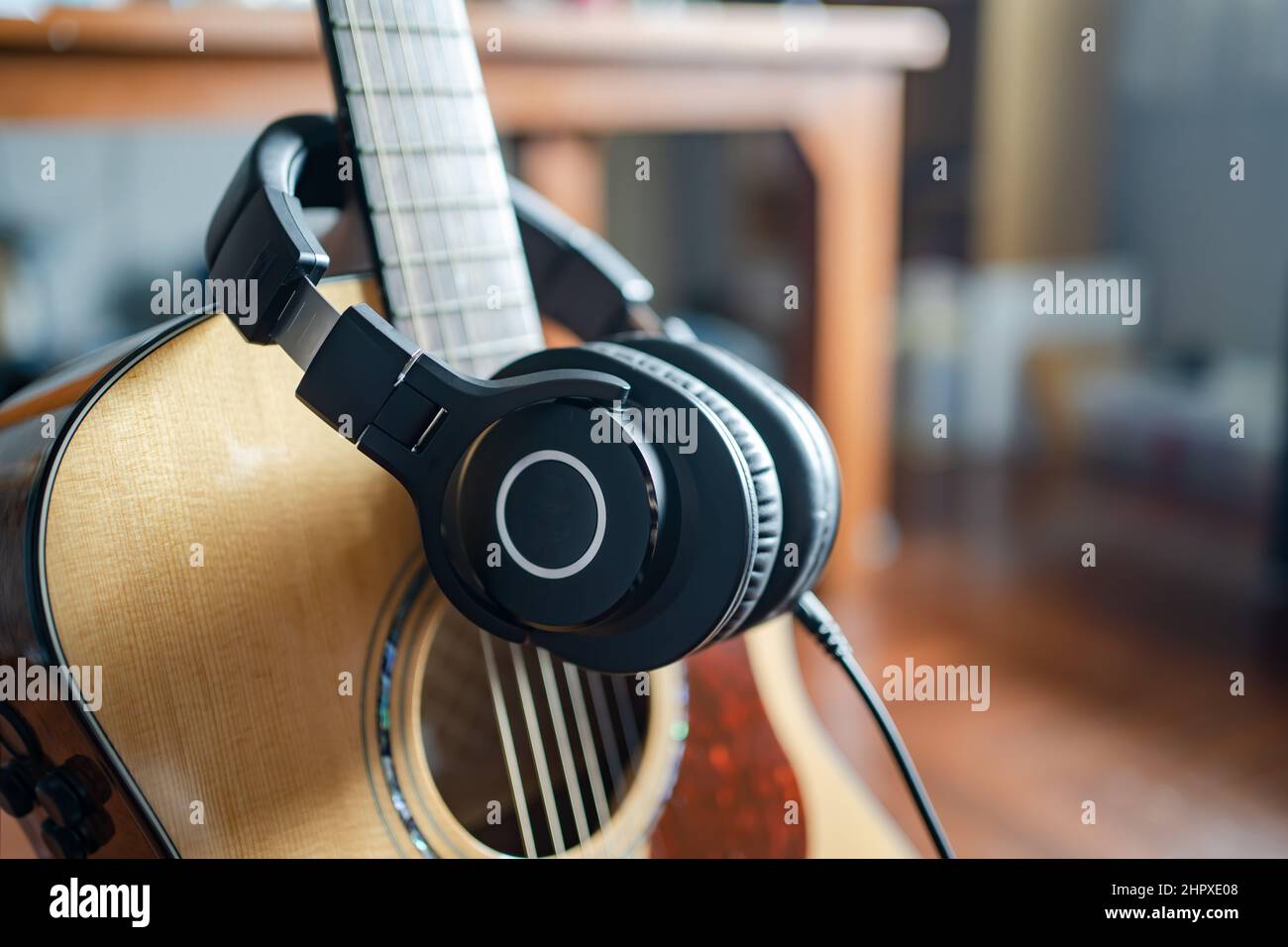 Akustische Gitarre und Ohrhörer im heimischen Raum Stockfoto
