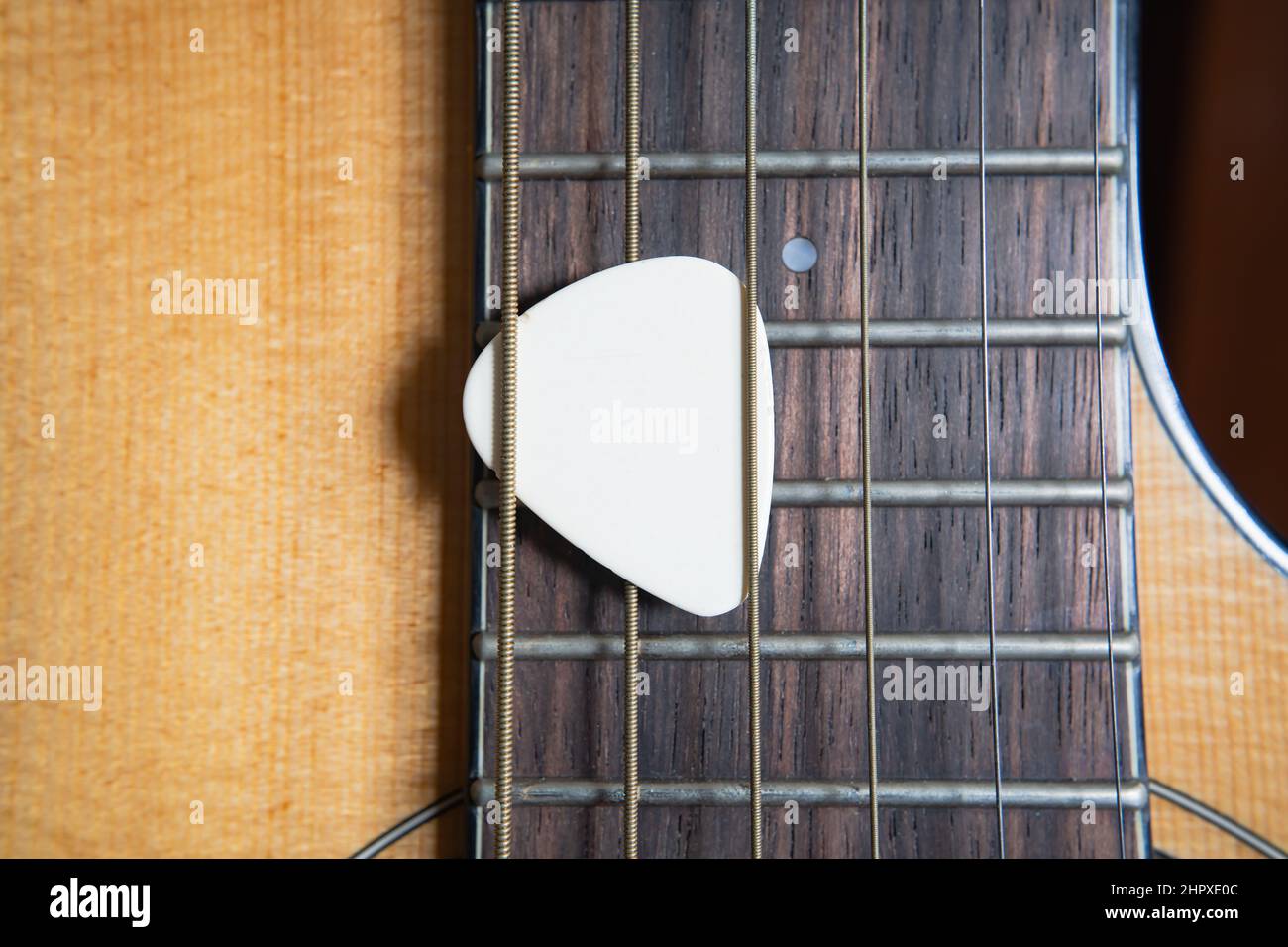 Weiße Gitarre Pick auf einer akustischen Gitarre Stockfoto