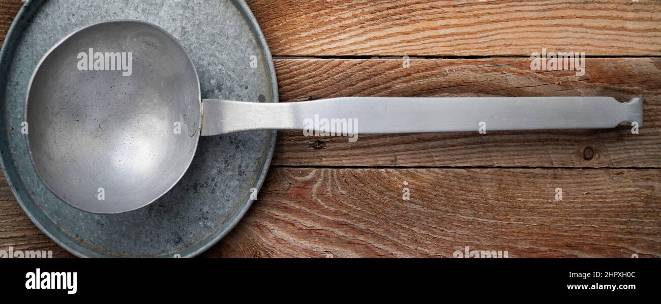 Alte Aluminium-Küchenpfanne auf einem hölzernen Hintergrund Stockfoto