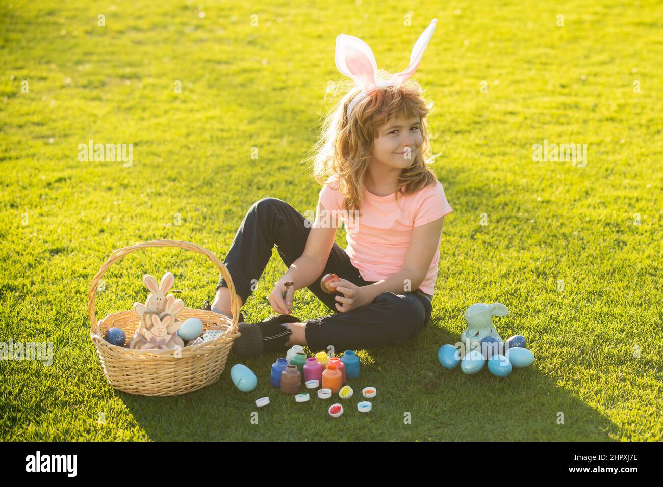 Osterhasen Kinder. Kind Junge in Hase Osterohren malen Eier. Niedlicher ...