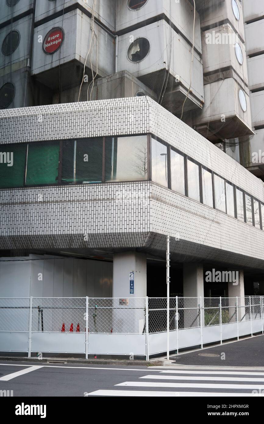 Basis des Nakagin Capsule Tower in Tokio mit einem Zaun um ihn herum. Stockfoto