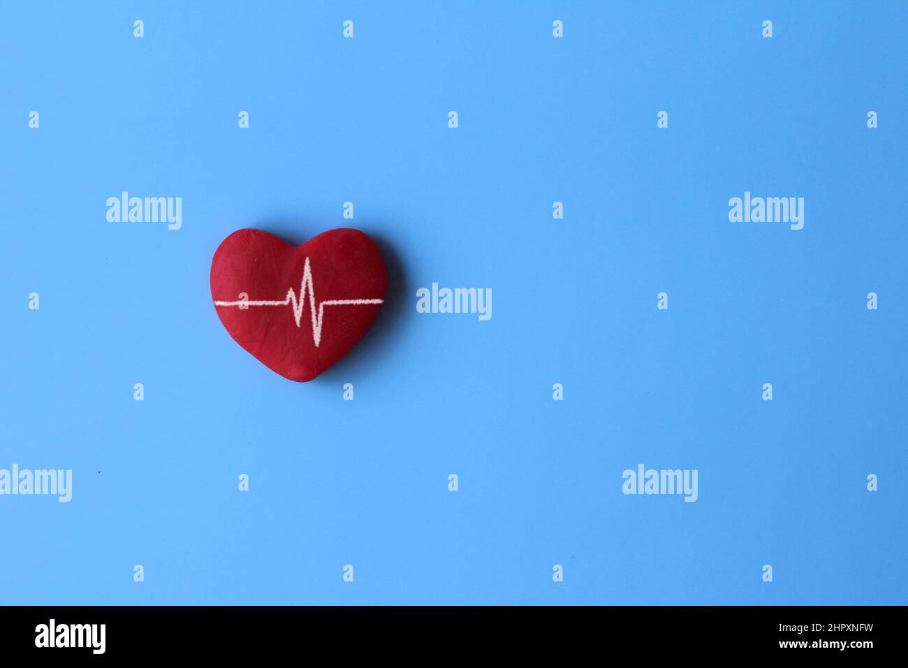 Draufsicht auf rotes Herz und Herzschlaglinie auf blauem Hintergrund mit Platz für Text. Stockfoto