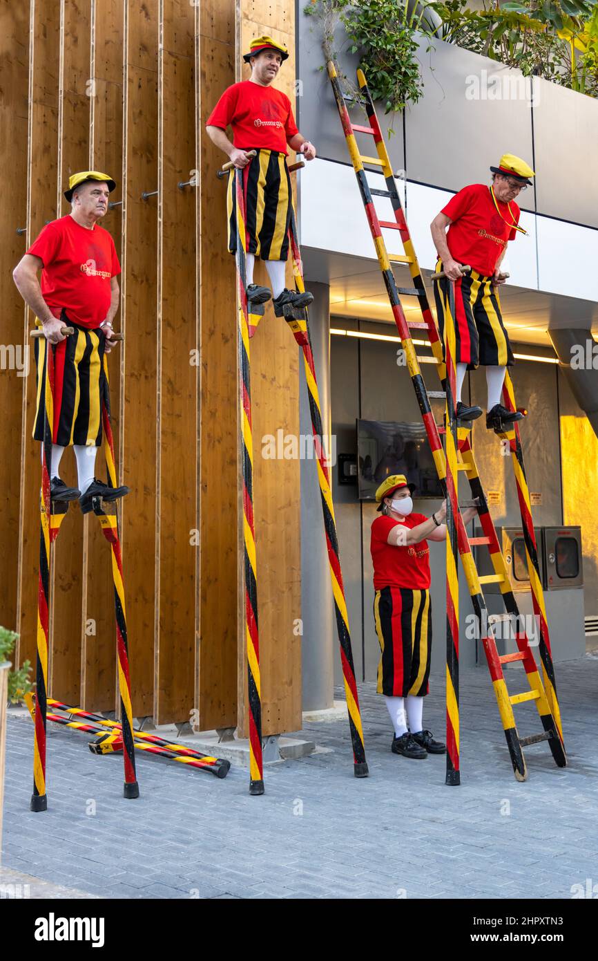 Belgische Stelzenläufer machen eine Pause vor dem belgischen Pavillon im Mobilitätsviertel auf der Dubai EXPO 2020 in den Vereinigten Arabischen Emiraten. Stockfoto