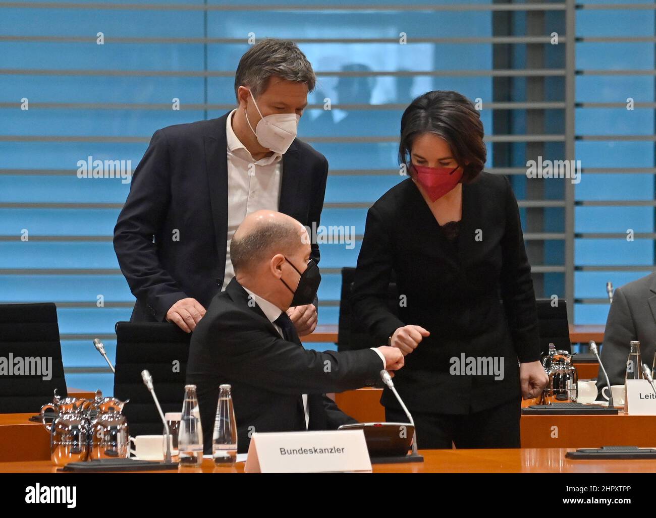 Berlin, Deutschland. 24th. Februar 2022. Robert Habeck (Bündnis 90/die Grünen), Bundesminister für Wirtschaft und Klimaschutz, Bundeskanzler Olaf Scholz (SPD, Front) und Außenministerin Annalena Baerbock (Bündnis 90/die Grünen) begrüßen sich vor Beginn eines Sicherheitskabinetreffens. Russische Truppen haben ihren Angriff auf die Ukraine begonnen. Quelle: John MacDougall/AFP Pool /dpa/Alamy Live News Stockfoto