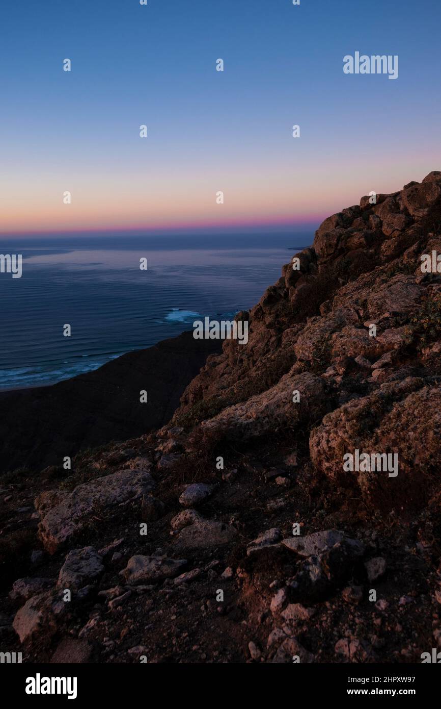 Blick auf die Berge auf das Meer und das kleine Dorf bei Sonnenuntergang Stockfoto