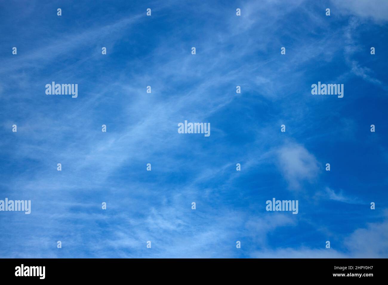 Die Wolken des Cirrus in großer Höhe werden durch Eispartikel in der kalten oberen Atmosphäre gebildet. Winde in solchen Höhen führen dazu, dass die Partikel Wölkchen bilden Stockfoto