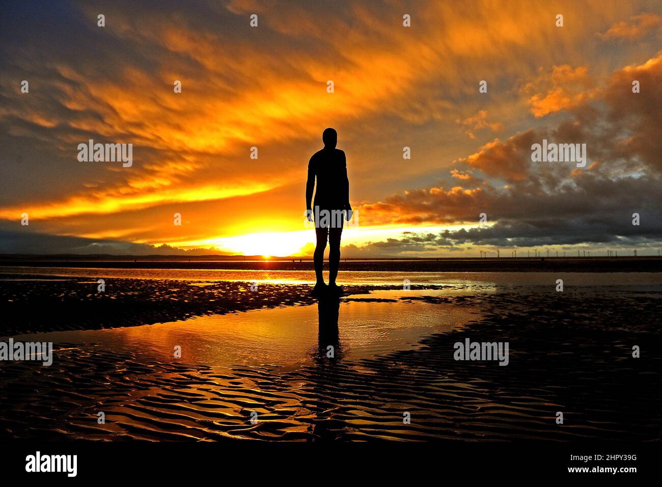 Winteruntergang am Crosby Beach, während die Anthony Gormley Statuen ohne Angst vor der kommenden Dunkelheit stehen, 11th. Mai 2015. Stockfoto