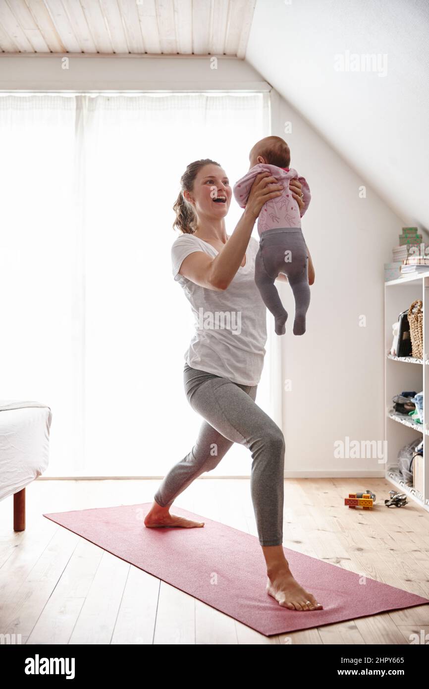 Körperbewusste Mutter und Baby. Aufnahme einer attraktiven jungen Frau, die sich beim Yoga mit ihrem kleinen Mädchen verklebt. Stockfoto