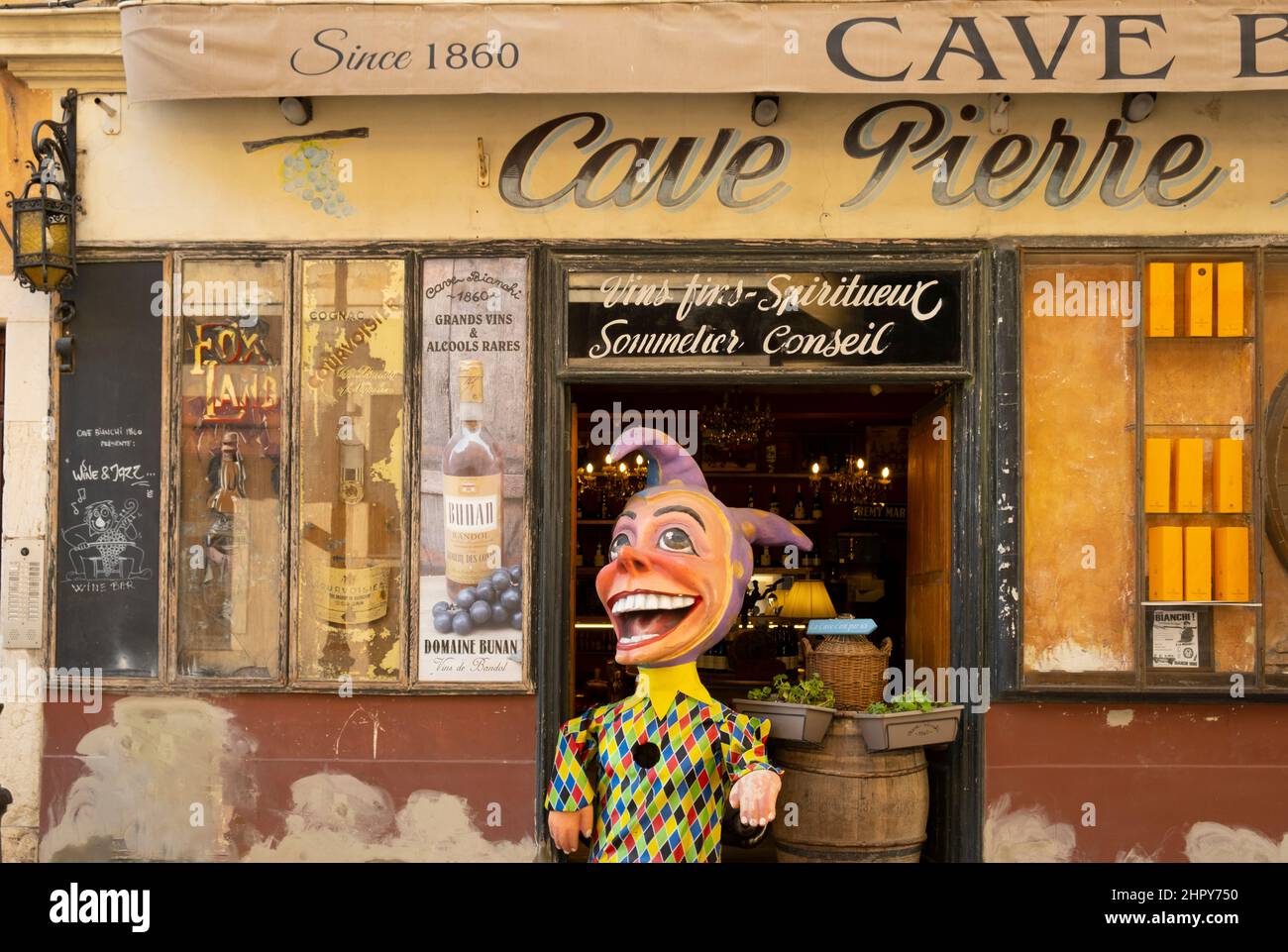 Ein Weinladen mit einer Karnevalsfigur im Eingangsbereich. Nizza, Frankreich Stockfoto
