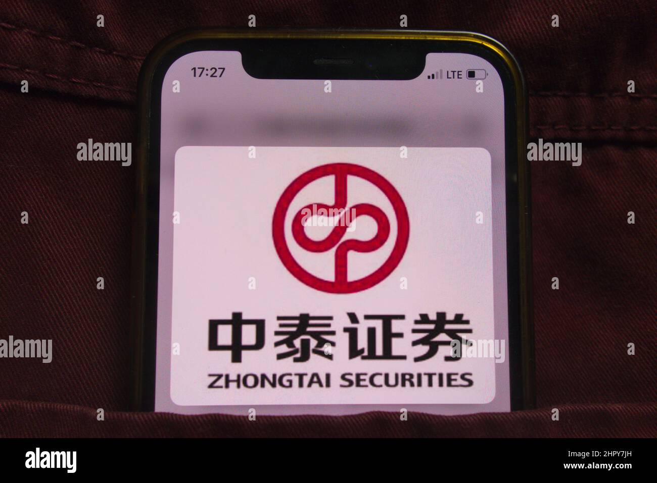 KONSKIE, POLEN - 22. Februar 2022: Das Firmenlogo von Zhongtai Securities wird auf dem Mobiltelefon in der Jeans-Tasche versteckt angezeigt Stockfoto