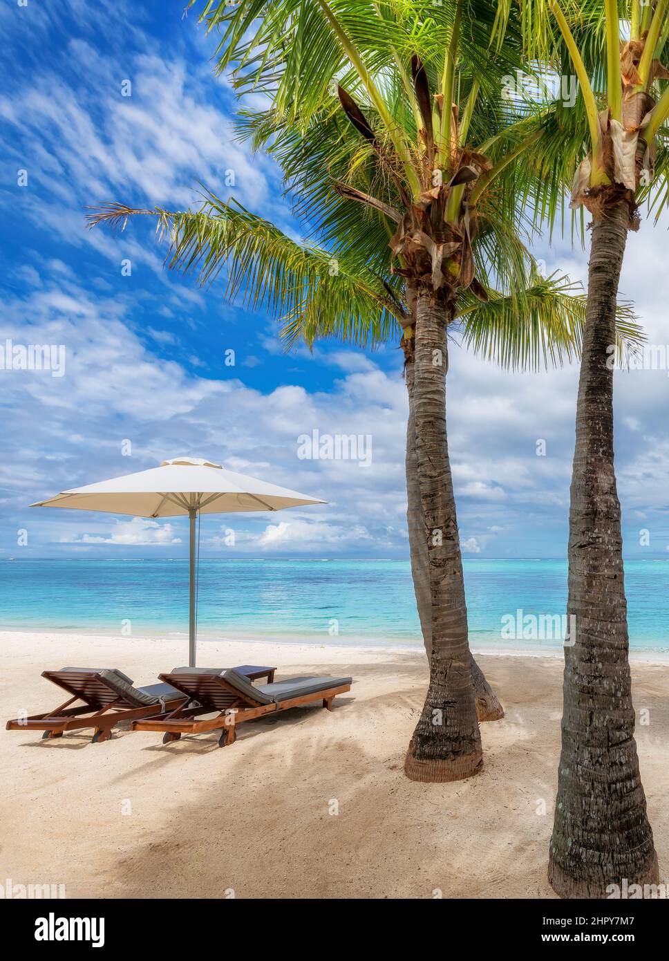 Palmen, Sonnenschirme und Stühle im tropischen, sonnigen Strandresort auf der Insel Mauritius. Stockfoto Palmen, Sonnenschirme und Stühle im tropischen, sonnigen Strandresort auf der Insel Mauritius. Stockfoto
