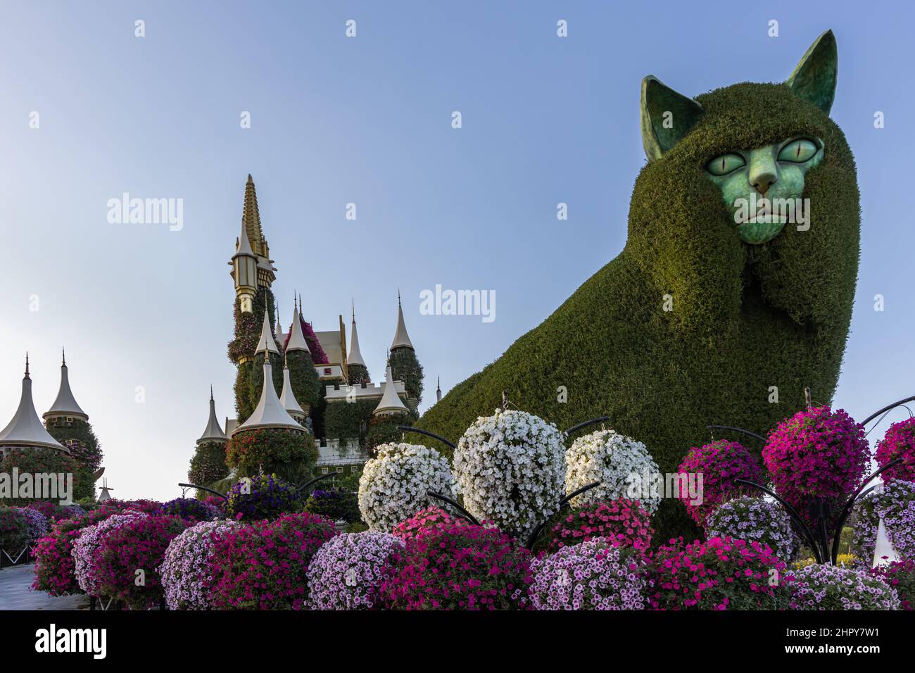 Eine riesige Katze und ein Märchenschloss inmitten der prächtigen Blumenpracht im Dubai Miracle Garden, Vereinigte Arabische Emirate. Stockfoto