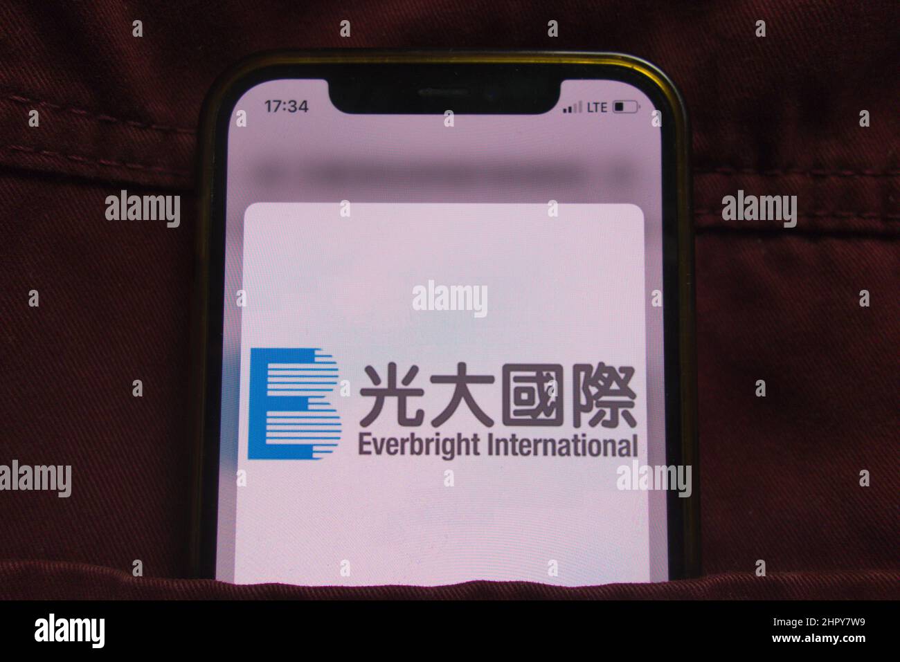 KONSKIE, POLEN - 22. Februar 2022: China Everbright International Limited Logo auf dem Mobiltelefon, versteckt in der Jeans-Tasche Stockfoto