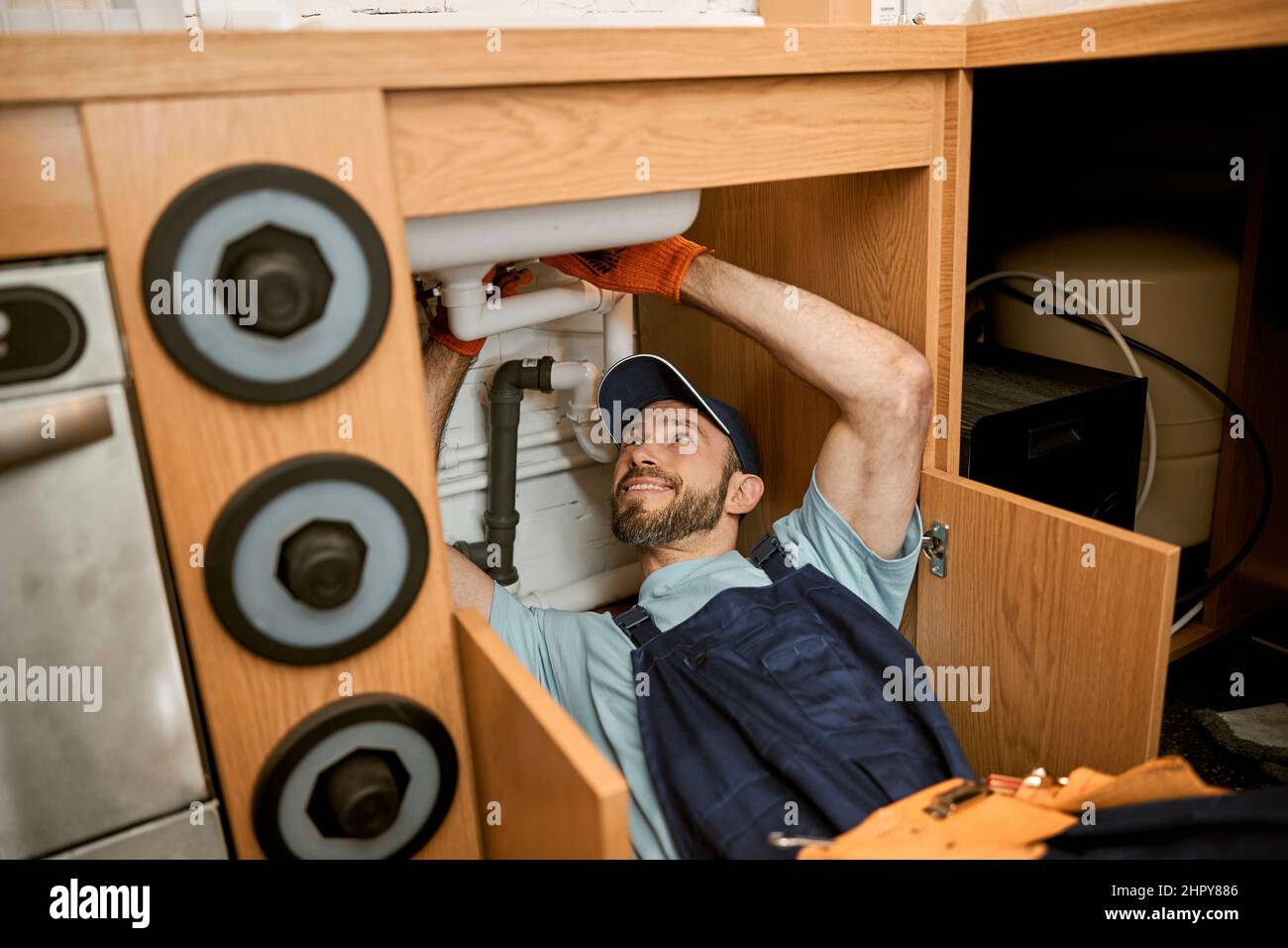 Fröhliche Klempner Befestigung Spülbecken Rohr in der Küche Stockfoto