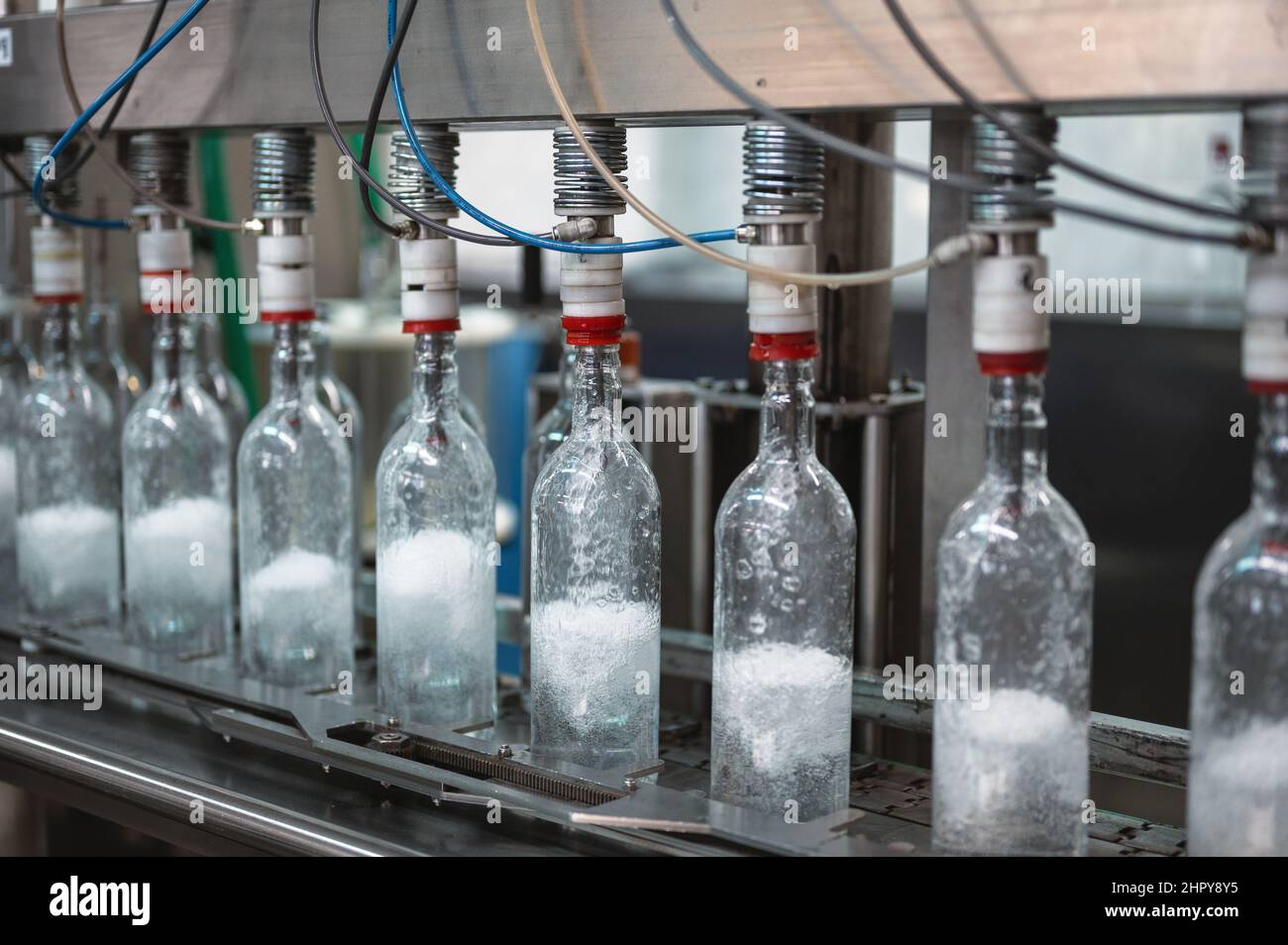 Füllen von Glasflaschen mit Wodka-Getränk auf der Produktionslinie Stockfoto