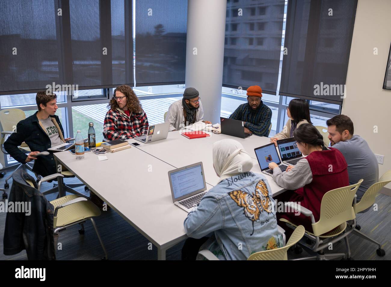 Nahaufnahme von Studenten, die an einem Tisch sitzen und miteinander kommunizieren Stockfoto