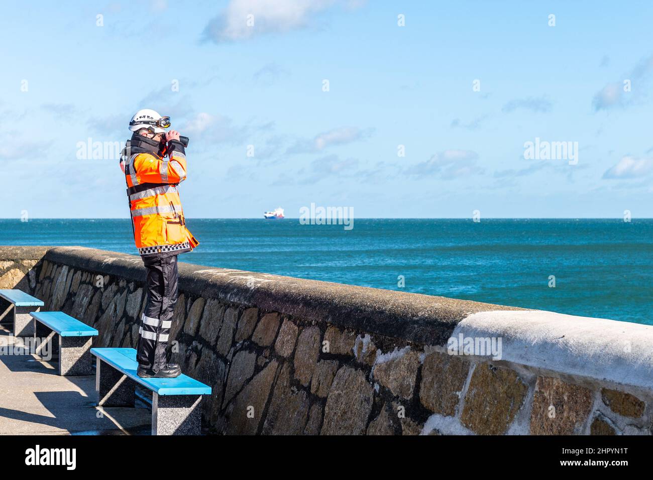Dun Laoghaire, Irland. 24th. Februar 2022. Ein Mitglied der irischen Küstenwache scannt das Meer vom Hafen von Dun Laoghaire aus und sucht nach einer vermissten Person. Quelle: AG News/Alamy Live News Stockfoto Dun Laoghaire, Irland. 24th. Februar 2022. Ein Mitglied der irischen Küstenwache scannt das Meer vom Hafen von Dun Laoghaire aus und sucht nach einer vermissten Person. Quelle: AG News/Alamy Live News Stockfoto