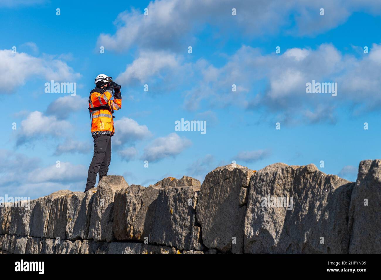 Dun Laoghaire, Irland. 24th. Februar 2022. Ein Mitglied der irischen Küstenwache scannt das Meer vom Hafen von Dun Laoghaire aus und sucht nach einer vermissten Person. Quelle: AG News/Alamy Live News Stockfoto Dun Laoghaire, Irland. 24th. Februar 2022. Ein Mitglied der irischen Küstenwache scannt das Meer vom Hafen von Dun Laoghaire aus und sucht nach einer vermissten Person. Quelle: AG News/Alamy Live News Stockfoto