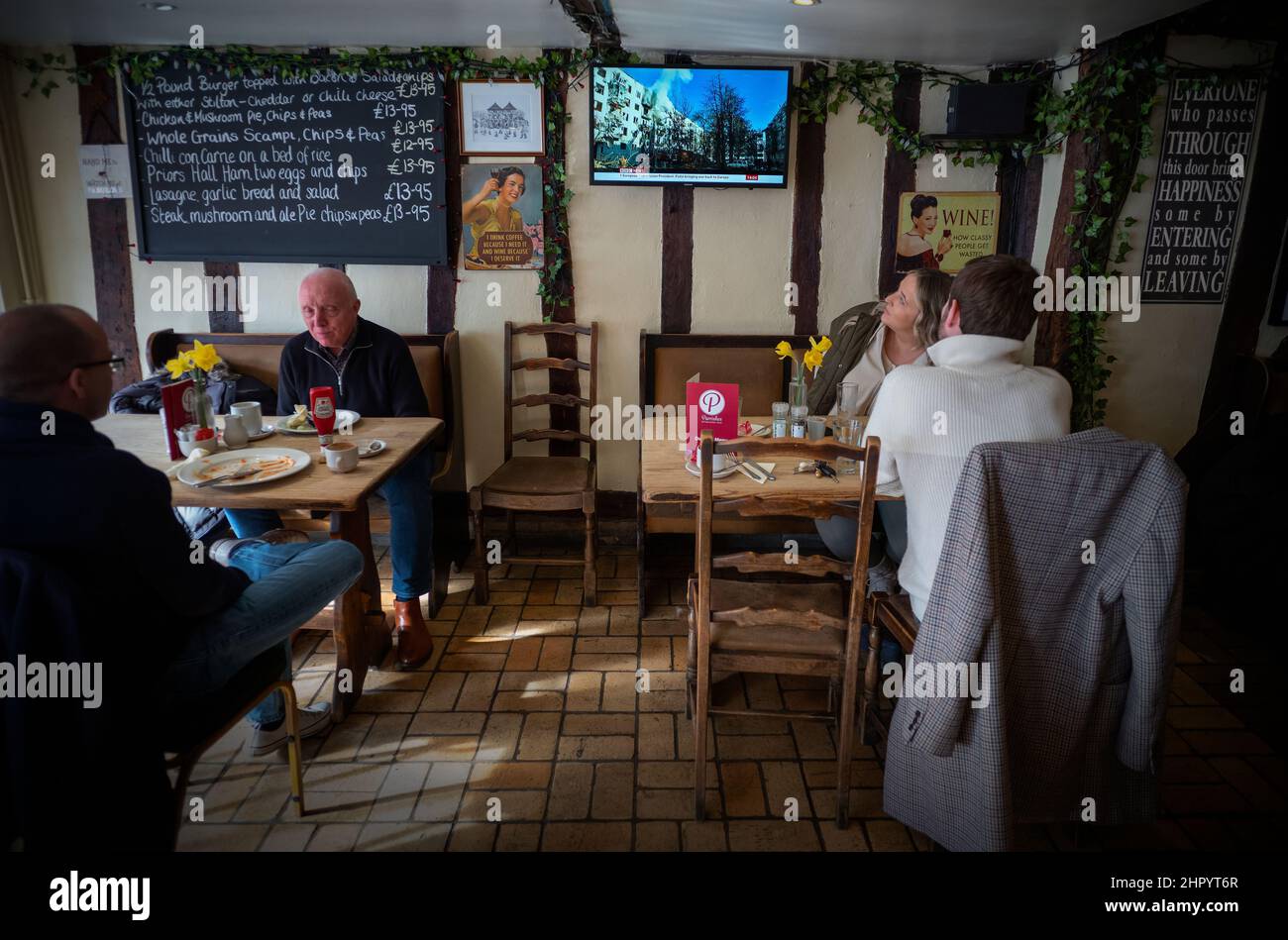 Russland erobert die Ukraine, im Fernsehen in der Weinbar Thaxted Essex, Großbritannien. 24th. Februar 2022. Während Kunden der Parrisges Wine Bar in Thaxted Essex UK ihr Mittagessen einnehmen, zeigt das Fernsehgerät Berichte auf der BBC, die die Invasion der Ukraine durch Russland heute zeigen. Kredit: BRIAN HARRIS/Alamy Live Nachrichten Stockfoto