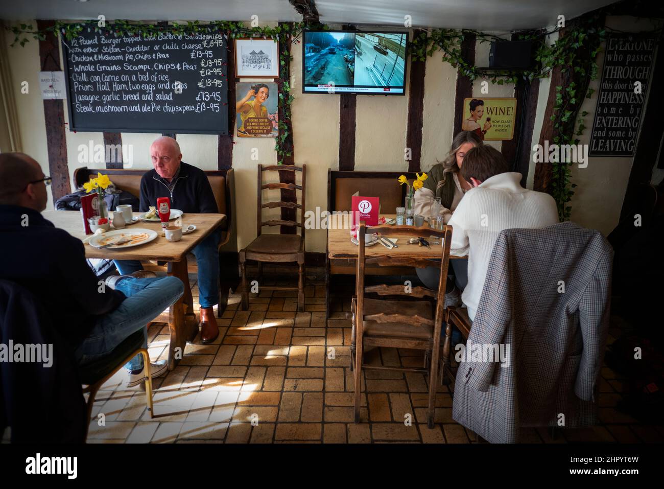 Russland erobert die Ukraine, im Fernsehen in der Weinbar Thaxted Essex, Großbritannien. 24th. Februar 2022. Während Kunden der Parrishes Wine Bar in Thaxted Essex UK ihr Mittagessen einnehmen, zeigt das Fernsehgerät Berichte auf der BBC, die die Invasion der Ukraine durch Russland heute zeigen. Kredit: BRIAN HARRIS/Alamy Live Nachrichten Stockfoto
